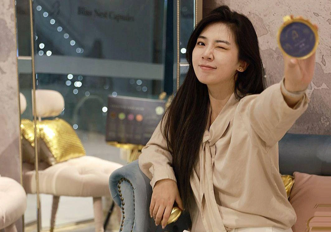 At the store, a lady is holding a bird's nest capsule